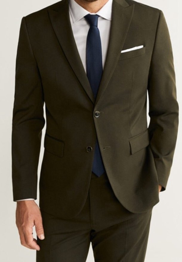 Abito verde oliva scuro con una vestibilità slim, giacca monopetto, rever a punta e due tasche. Abbinato a una camicia bianca e a una cravatta blu navy.