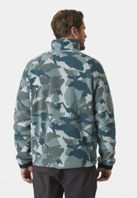 Sudadera de forro polar en un patrón de camuflaje azul y gris, con un cuello alto, puños elásticos y un acabado suave y texturizado.