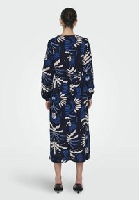 Navyfarbenes Kleid mit einem floralen Muster in Blau, Creme und Grün, das lange Ärmel, einen Taillengürtel und eine Midi-Länge mit glatter Textur aufweist.