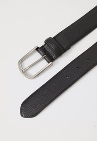 Cinturón de cuero negro con una textura suave, que presenta una hebilla rectangular de plata, un extremo cónico y múltiples agujeros para ajustar el tamaño.