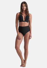 Zwart bikiniset met een diepe halslijn bovenstuk en een hooggetailleerde bikinionderkant. Het ontwerp bestaat uit zachte stof en minimale details.