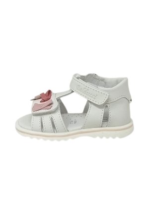 Sandalo bianco per bambino con decorazione con fiocco rosa, cinturino regolabile alla caviglia e design a punta aperta su sfondo bianco.