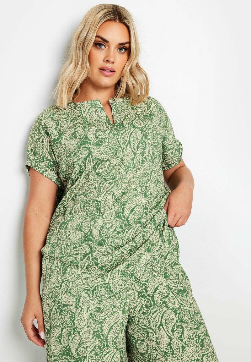 Blusa verde a motivo paisley con colletto a scollo a V e maniche corte, realizzata in tessuto leggero, con una vestibilità comoda.