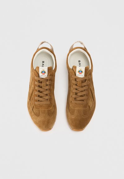 Sapatilhas de camurça castanhas com sola de borracha, com um design com atacadores, uma etiqueta com o logotipo na língua e detalhes de costura minimalistas.