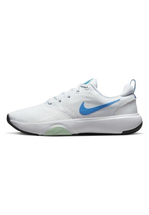 Zapatilla de correr Nike blanca con el logo azul, acento verde claro en la suela y suela exterior negra, mostrada de perfil sobre fondo blanco.