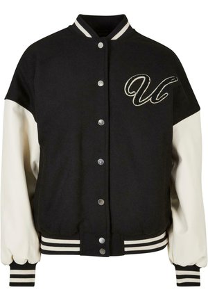 Sort varsityjakke med cremefarvede ærmer. Har knaplukning, ribbede manchetter og kant, samt en broderet "U" design på brystet.