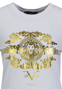 Weißes T-Shirt mit einem goldmetallischen Löwengrafik, verziert mit ornamentalen Elementen und dem Text "1969 ITALIA" darunter. Glatte Textur, Rundhalsausschnitt.