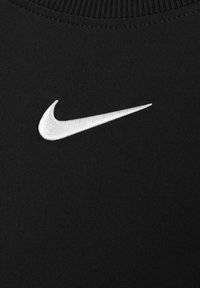 Black athletic shirt with a crew neckline, made of ribbed fabric; features a prominent white embroidered Nike swoosh logo on the chest.