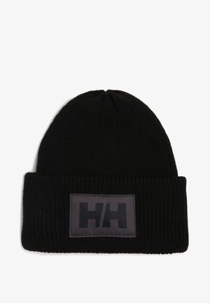 Schwarze Strickmütze mit umgeschlagenem Bündchen, ausgestattet mit einem rechteckigen grauen Patch mit dem schwarzen "HH"-Logo. Strukturierter, kuscheliger Stoff.