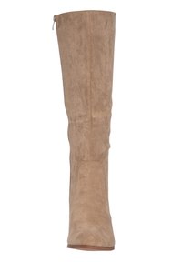 Bota de ante beige hasta la rodilla con una textura suave, silueta ajustada y una cremallera lateral para facilitar su uso. Forma elegante con mínimas adornos.