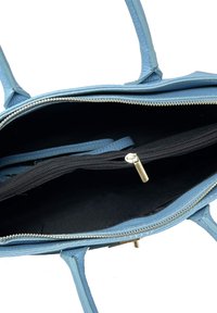 Jasnoniebieska skórzana torebka na zamek błyskawiczny, zewnętrzną kieszenią i dwoma uchwytami. Posiada fakturowany materiał oraz czarne wyściółkę.