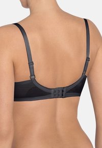 Sujetador negro con tirantes ajustables, cierre de gancho y ojo, y una textura suave con respaldo de malla para mayor transpirabilidad.