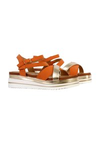 Orangefarbene Riemchensandalen mit metallischen goldenen Akzenten und weißer Gummisohle. Besitzt eine Mischung aus glatten und strukturierten Materialien.