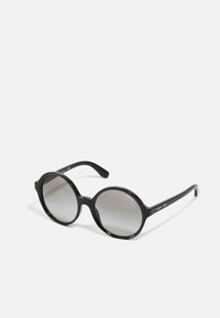 Óculos de sol redondos pretos com um acabamento brilhante, lentes cinzentas em degradê e hastes texturizadas que exibem um logótipo. Construção leve em plástico.