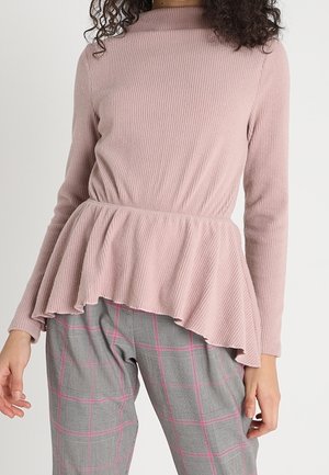 Pink ribbed long-sleeve top with a peplum hem. Paired with gray plaid pants featuring pink lines, creating a textured and layered look.
