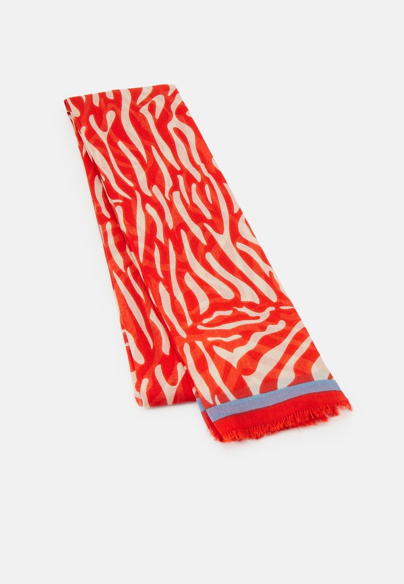 Longue écharpe rectangulaire avec des rayures zébrées abstraites rouge vif et blanc et une petite frange bleue et rouge en bordure à une extrémité.