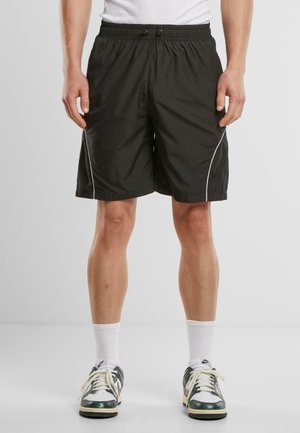 Sorte sportshorts med elastisk talje, der har hvid piping langs siderne. Fremstillet af letvægtsstof, knælængde design.