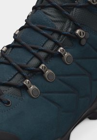 Σκούρο μπλε μποτάκι πεζοπορίας με μαύρα και μπλε στρογγυλά κορδόνια, μεταλλικά παπούτσια και ανάγλυφο συνθετικό υλικό ανώτερου μέρους.