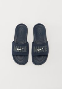 Sandale slide de culoare albastru închis, cu talpă texturată, bretele late cu logo-ul "NIKE" în argintie reflectorizantă. Fabricate din material sintetic durabil.