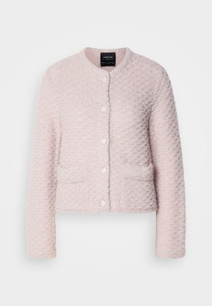 Veste courte rose clair en tissu texturé, avec un col rond, des boutons sur le devant et deux poches décoratives.
