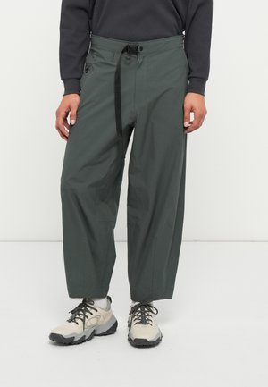 Zelene lahke cargo hlače z sproščenim krojem, ki imajo nastavljiv drawstring pas in stranske žepe. Narejene so iz gladkega, trpežnega materiala.