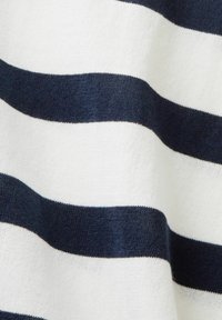 Pletený svetr s horizontálními pruhy v námořnické modré a bílé barvě, které se střídají. Měkká textura s hladkým povrchem; klasický design.