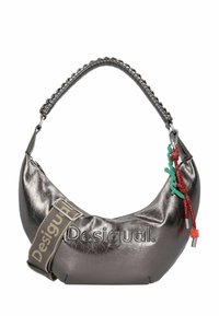 Bolso de mano en forma de media luna de color plata metálico con correa fruncida, logo de "Desigual", correa de tela gruesa y ajustable, y borlas decorativas rojas y verdes.