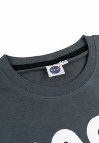 T-shirt in cotone grigio con scollatura a girocollo e un'etichetta con il logo NASA, con testo bianco in grassetto sulla parte anteriore.