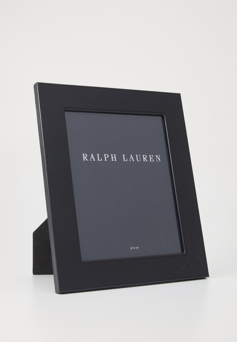 Μαύρη δερμάτινη κορνίζα φωτογραφιών με κομψό σχεδιασμό, διαθέτοντας διαφανές μπροστινό μέρος για φωτογραφία 8'' x 10'' και ανυψωμένη υποστήριξη πίσω.