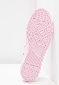 Sole di sneaker in gomma rosa con motivo di presa testurizzato, caratterizzata da design geometrici e logo "Converse All Star" impresso.