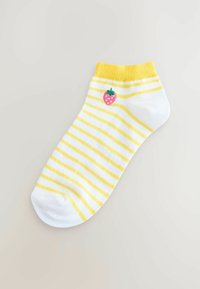 Weiße Knöchelsocken mit gelben Streifen und einer aufgestickten pinken Erdbeere auf der Außenseite. Mit einem gerippten gelben Bündchen.