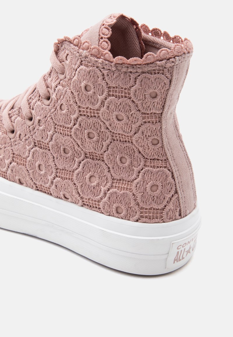 Sneaker alte viola malva con suola bianca, decorata con ricamo floreale in pizzo e bordatura smerlata intorno al colletto alla caviglia.