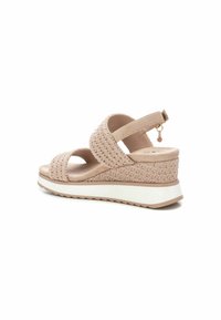 Sandal i wedge color beige chiaro con una texture intrecciata e doppi cinturini. Presenta un dettaglio con fibbia laterale e una suola bianca e testurizzata.