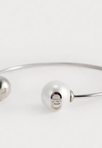 Bracciale d'argento con una grande perla bianca e una sfera grigia più piccola, finitura lucida e un dettaglio di chiusura unico per una chiusura sicura.