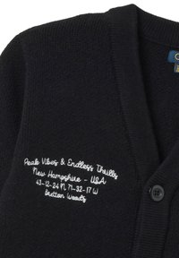 Dunkelblauer Strickjacke mit gerippter Struktur und weißer, bestickter Schrift. Verfügt über eine Knopfleiste und gestickte Akzente am Kragen.