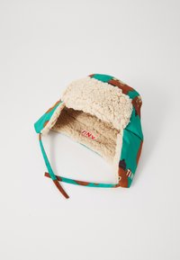 Chapeau coloré pour enfant avec un tissu extérieur comportant un imprimé d'ours, une doublure douce en fausse fourrure beige et des sangles réglables sous le menton.