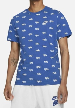 Blauwe katoenen T-shirt met een herhaald wit Nike-logo patroon. Ronde hals en korte mouwen. Zachte textuur met een relaxte pasvorm.