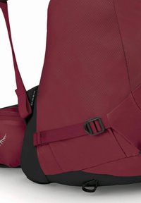 Zaino marrone con finitura testurizzata, accenti neri, spallacci regolabili e dettagli con fibbia laterale. Design compatto adatto per l'uso all'aperto.