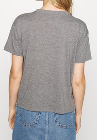 Grå kortärmad t-shirt i mjukt material, med rundad halsringning, avslappnad passform och något längre bakstycke.