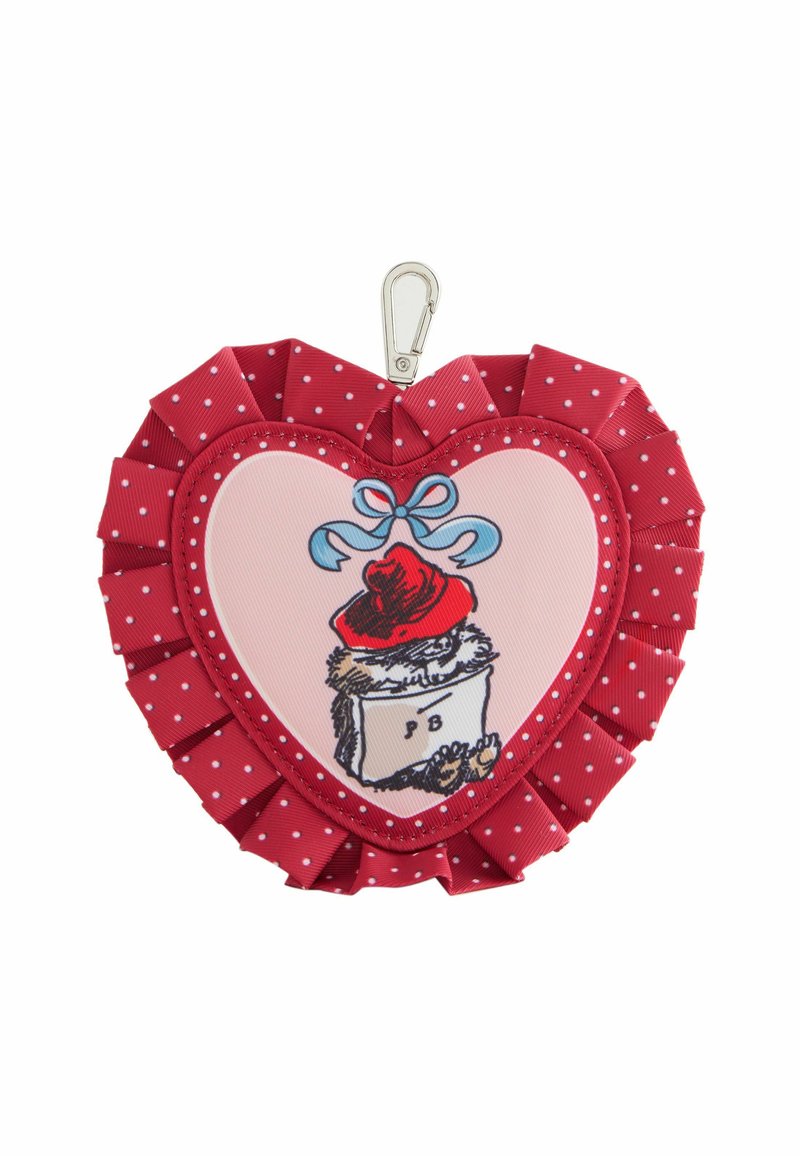 Rød hjerteformet tilbehør med hvide prikker, der har en central illustration, bølgede kanter og en metalclips til fastgørelse.