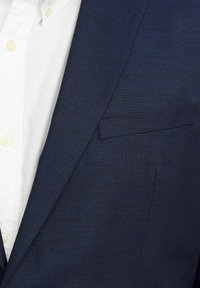Navy blazer with textured fabric and a single chest pocket, paired with a white button-up shirt featuring light yellow buttons.