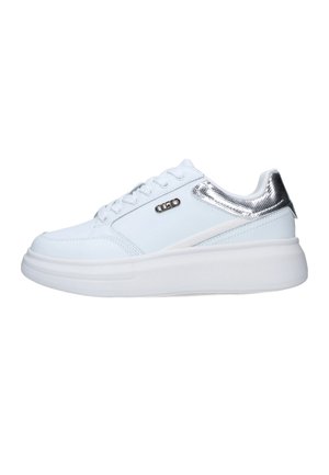 Zapatilla blanca con parte superior de cuero suave, detalles metálicos plateados en el talón y una gruesa suela de goma blanca. Presenta cierre con cordones.
