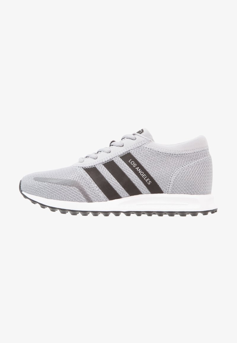 Gray athletic shoes with black stripes, lace-up design, lightweight mesh upper, and a textured rubber sole for enhanced grip.