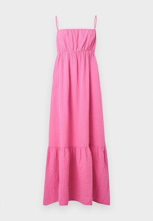 Φωτεινό ροζ μανίκωτο φόρεμα μάξι με λεπτές τιράντες, ραμμένη στο στήθος, σφιχτή μέση και βολάν στο τελείωμα σε απλό ανοιχτό φόντο.