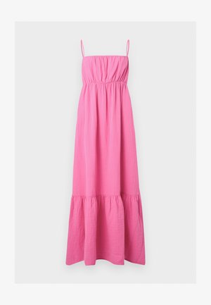 Robe maxi rose vif sans manches avec fines bretelles, buste froncé, taille cintrée et ourlet à volants sur fond clair uni.