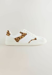 White sneaker featuring leopard print accents on the sides, textured leather and fabric materials, lace-up design, and rubber sole.
