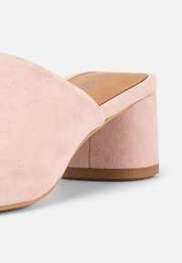 Ροζ σουέντ παπούτσι mule με τετράγωνο τακούνι και στρογγυλεμένη μύτη, με ταμπά εσωτερική σόλα και λαστιχένια εξωτερική σόλα.