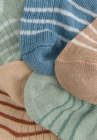 Pięć par skarpet w różnych kolorach: niebieskie w białe paski, zielone, beżowe w rdzawą stripes oraz w pastelowych odcieniach; dzianina bawełniana, miękka w dotyku.