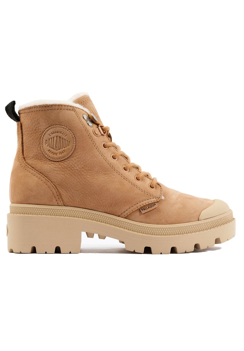 Bottines en cuir tan avec col rembourré, coque de protection en caoutchouc et semelle texturée. Présente un patch logo et un design à lacets.