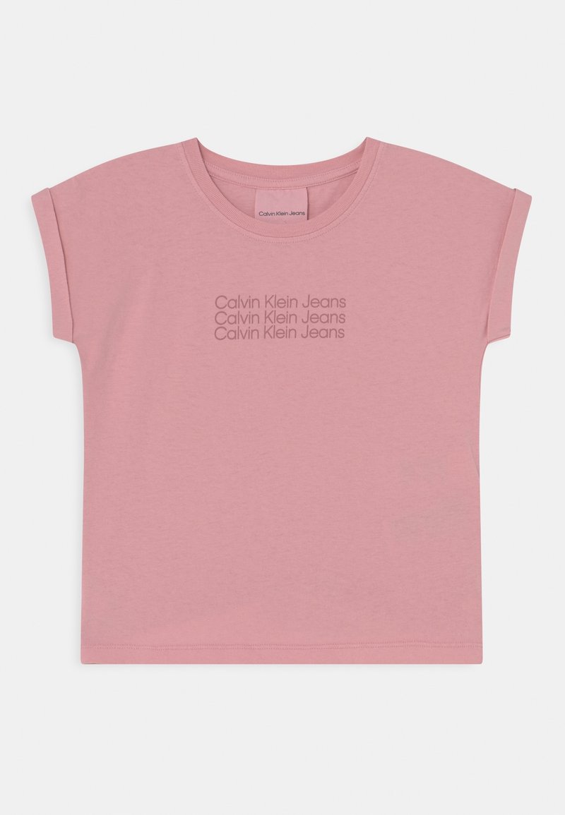 Różowy t-shirt z krótkim rękawem wykonany z bawełny, z okrągłym dekoltem. Na tkaninie powtarza się logo "Calvin Klein Jeans" w ciemniejszym odcieniu.